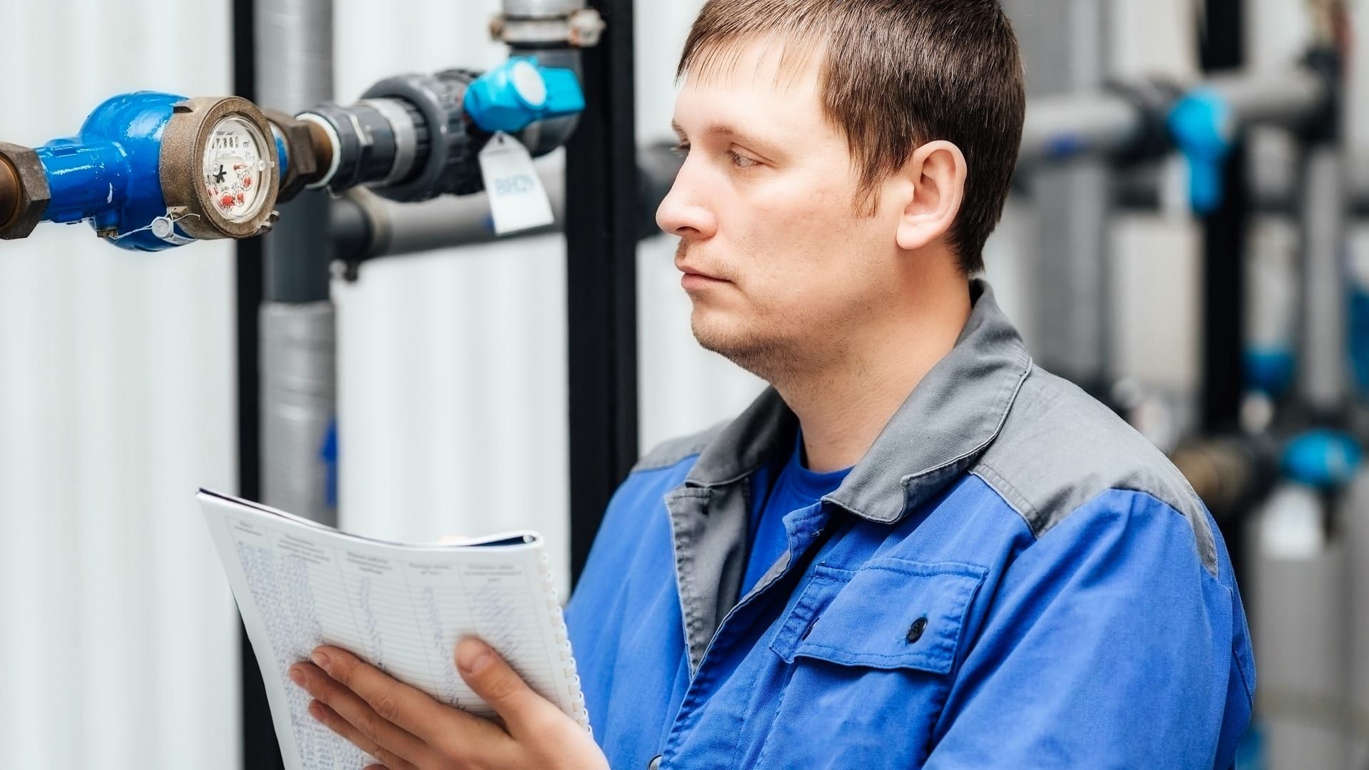 Ingeniero registrando lecturas de sensores y presión durante una auditoría hídrica de planta industrial