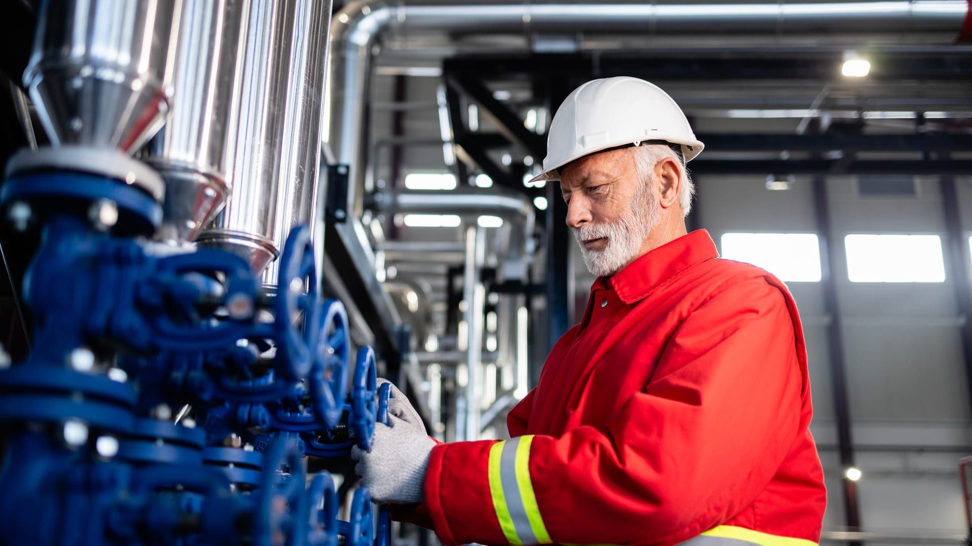 Técnico instalador trabajando en válvulas y tuberías de una depuradora industrial compacta